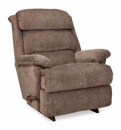 A light taupe-brown recliner chair is centered against a white background.    The chair has a padded back and seat with a textured fabric.  The back is slightly arched and has a tufted design. The armrests are oversized and upholstered in the same material as the rest of the chair.    The chair's base is a dark, wood-toned. The chair's design appears contemporary and supportive.