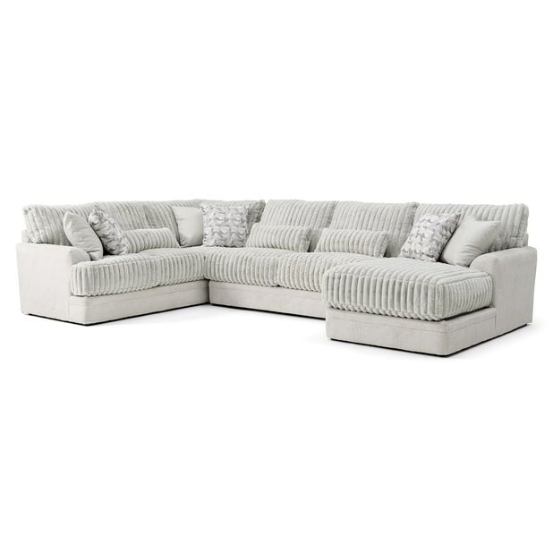 A modern, U-shaped sectional sofa in a light gray fabric with a ribbed texture is displayed against a plain white background. The sofa features a chaise lounge on the right side and plush, cushioned seating with a deep, comfortable design. It is adorned with several decorative pillows, including rectangular and square shapes, some with subtle white and gray patterned designs. The overall style is contemporary and cozy, suitable for a living room setting.