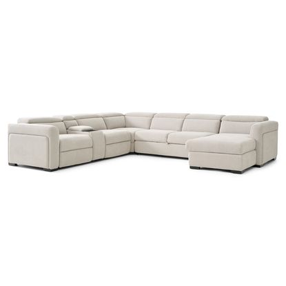 A light beige or cream-colored sectional sofa with a chaise lounge.   The sectional is an L-shape with multiple seating areas. The sofa has a modern design with clean lines, and the seating areas are padded, with visible cushioning. Each end of the sectional has armrests.   The sofa is presented against a plain white background, which allows the light beige color of the sofa to stand out clearly.