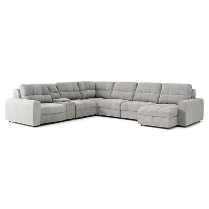 A light gray, sectional sofa is centered against a plain white background.    The sofa is an L-shape with a chaise lounge section extending from the main seating area. The upholstery appears to be a textured fabric with a subtle quilted pattern.  Each end of the sofa has padded armrests. A small, recessed storage space is visible in a section of the sofa.    The sofa is presented in a way that showcases its shape and style, and the soft light gray color makes it stand out.